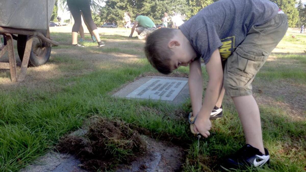 Max Miller, 5, works to clean of headstones at Puyallup’s Day of Service, which brought in more than 275 volunteers to beautify Woodbine Cemetery on Sept. 12.