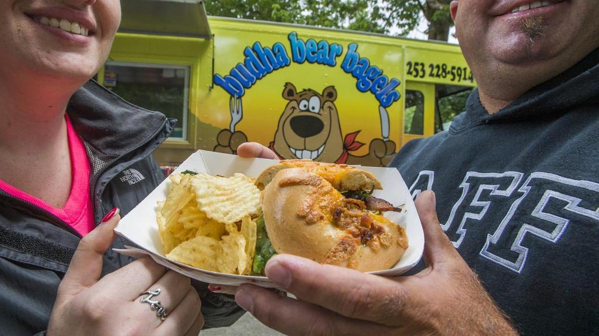 Ande Dunn and Darrin Shaw were happy to split a “Bad Ass Burger” from budha bear bagels at Food Truck Fest in Tacoma’s Wright Park. Budha bear bagels will make an appearance at Saturday’s Food Truck Frenzy at Bradley Lake Park in Puyallup.