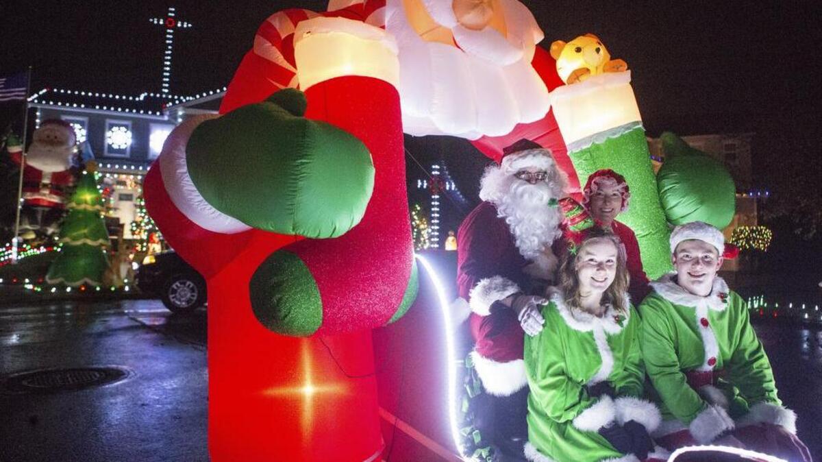 Clockwise from top left: Troy, Julie, Haylee and Ethan Halfaday sit in a sleigh in the cul de sac outside their house in Puyallup on Saturday night. Each year around Christmas, the Halfadays decorate their house and spread Christmas cheer to passing cars and neighbors.