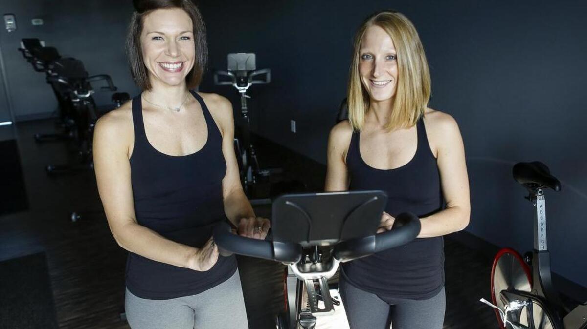 Amanda Looker, left, and Chelsy Looker-Carli stand for a portrait in the expanded Prana Hot Yoga and Body Sculpt in Puyallup. The recent expansion created a larger lobby and dedicated cycling room.