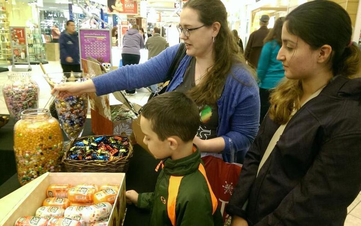 Katrina Hays and her son, William Sanitate, 7, and daughter Susana Cruz, 17, fill up on candy at the South Hill Mall for a family movie night.