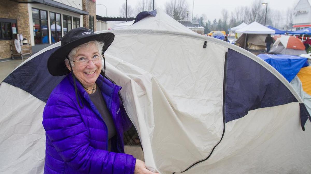 Sue McGowan shows off her tent in the parking lot of Chick-Fil-A in Puyallup on Wednesday. McGowan operated a Chick-Fil-A restaurant in Arkansas in the 1980s. People camped in the parking lot of Chick-Fil-A as part of a promotion for the opening of the restaurant. The first 100 customers receive a free meal each week for a year. Some people showed up at 5:15 a.m. Wednesday morning to camp in the parking lot.