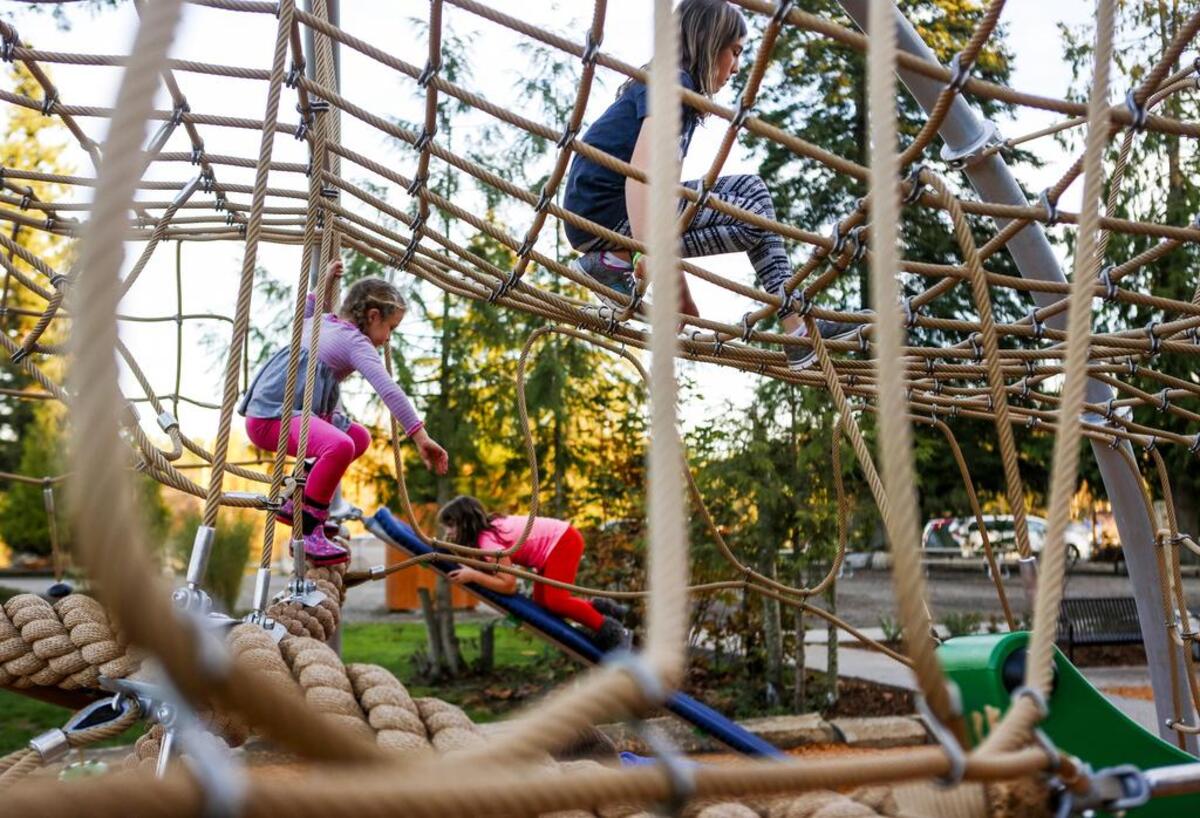Children play on a rope dome at Meridian Habitat Park in Puyallup.