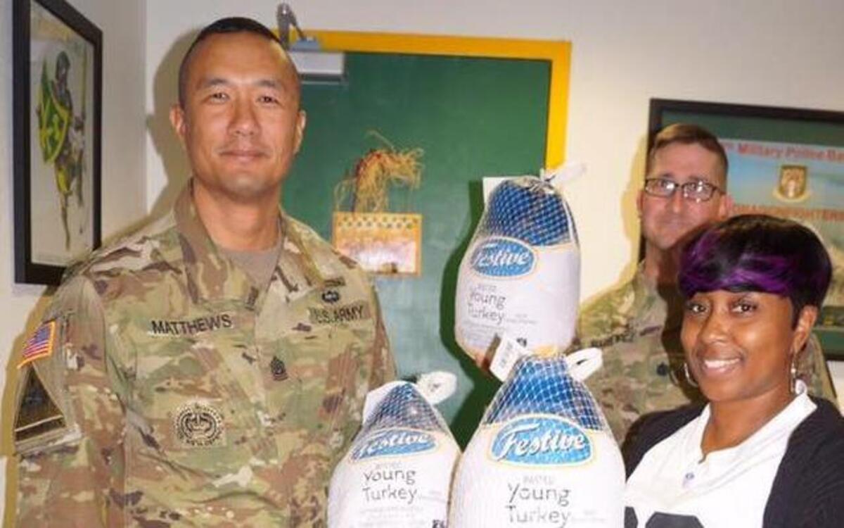 Command Sgt. Maj. Jon Matthews, left, of the 593rd Sustainment Brigade at Joint Base Lewis-McChord, holds a turkey with other service members during the the 2016 Operation Turkey Drop event.