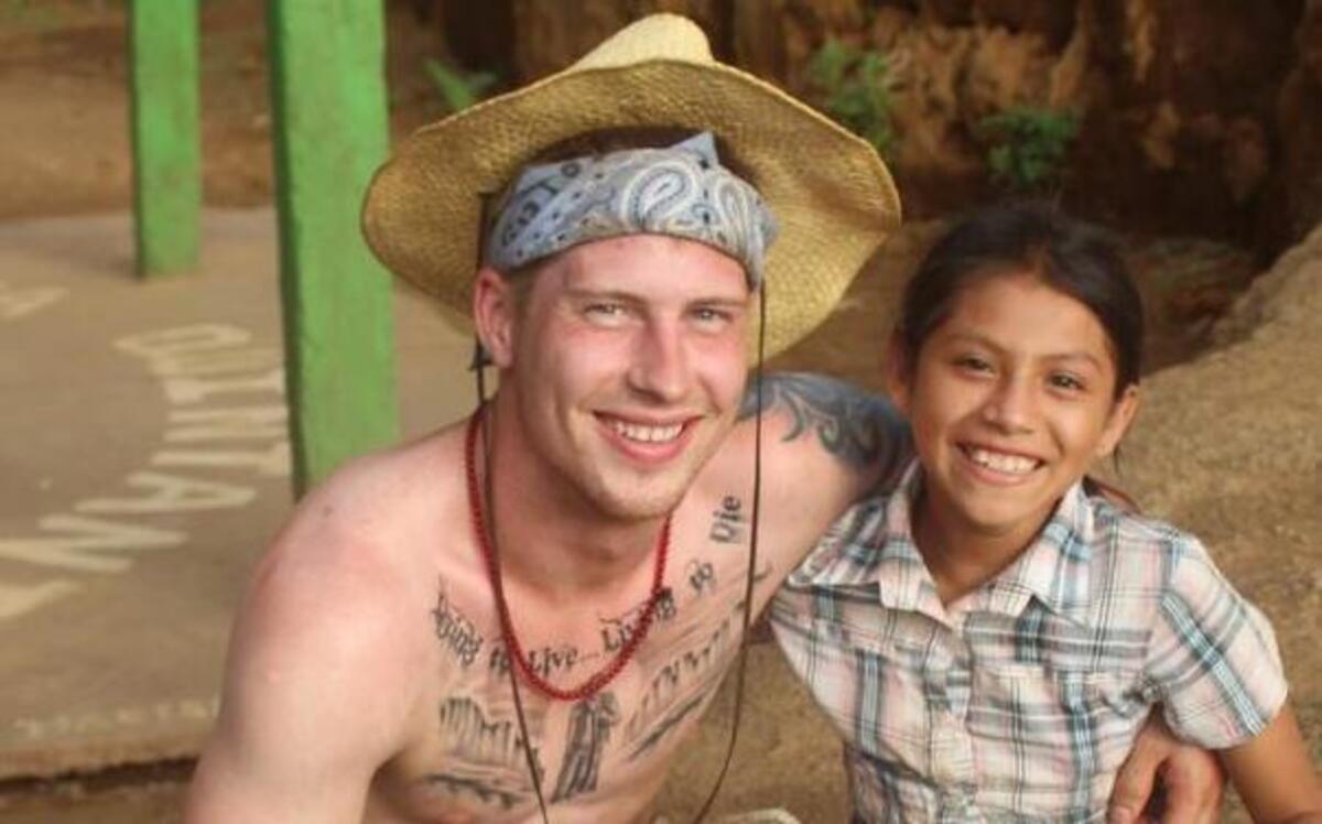 
Pierce College student Chris Sanders takes a break from his hard work of planting coffee bean plants to pose for a photo with a local.
