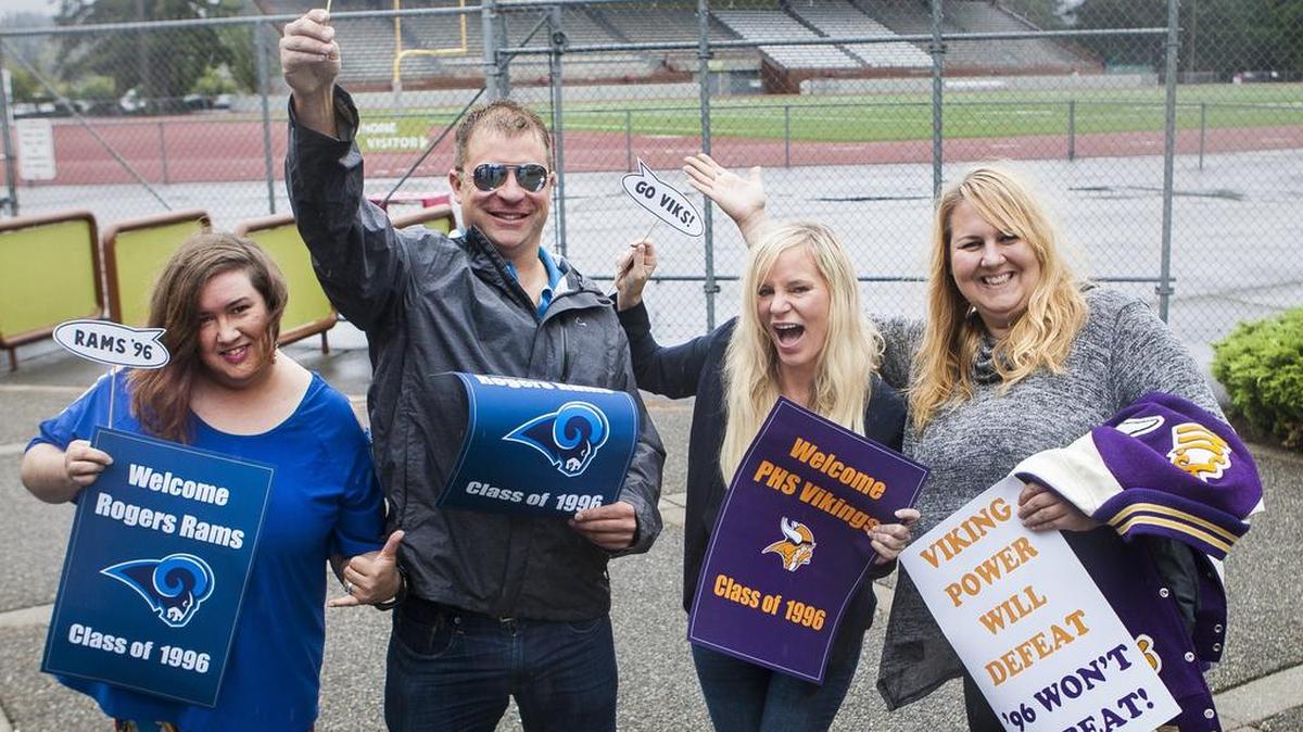 Rogers High alums Kendra Aguilar and Kevin Mauermann unite with Puyallup High alums Gale McArthur and Mandy Johnson outside of Sparks Stadium in Puyallup. Puyallup and Rogers are bringing together graduating classes from 1996 for a joint class reunion. The reunion is scheduled for 6 p.m. Saturday at Pioneer Park Pavilion.