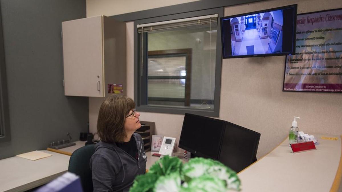 Ann Schumacher, an administrative intern at Maplewood Elementary, demonstrates the video intercom system installed at the school in Puyallup on Friday.
