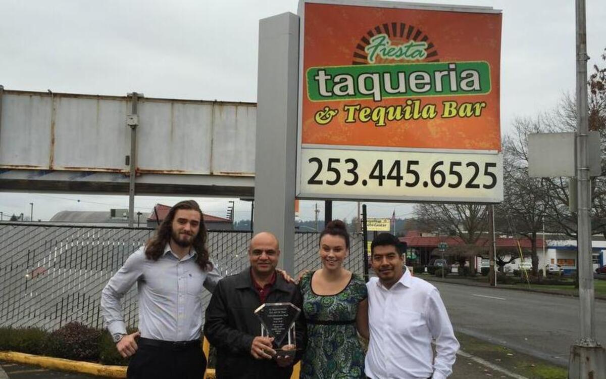 Kollyn Davis, Ramesh Kumar, Katie Ellis and Fernando Luis, from left, gather for a photo in front of the Fiesta Taqueria in downtown Puyallup. Kumar and his staff were recently honored with an award for their dedication to community service.