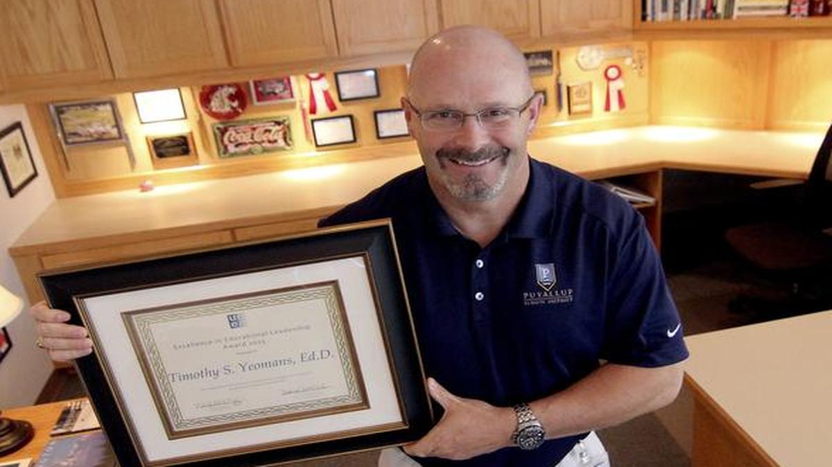 Puyallup School District Superintendent Dr. Tim Yeomans was recently awarded the Excellence in Education Leadership from the ECEU. Yeoman proudly holds the award commendation in his downtown Puyallup office at the district’s headquarters building on Friday.