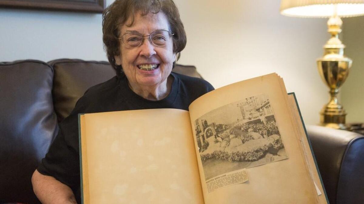 Elaine Joy Mahaffie holds up a scrapbook with a photograph of her Daffodil Queen float. Mahaffie was a crowned Puyallup Daffodil Queen in 1951. According to articles printed by The News Tribune, there were 15 million daffodils used throughout the entirety of that festival.