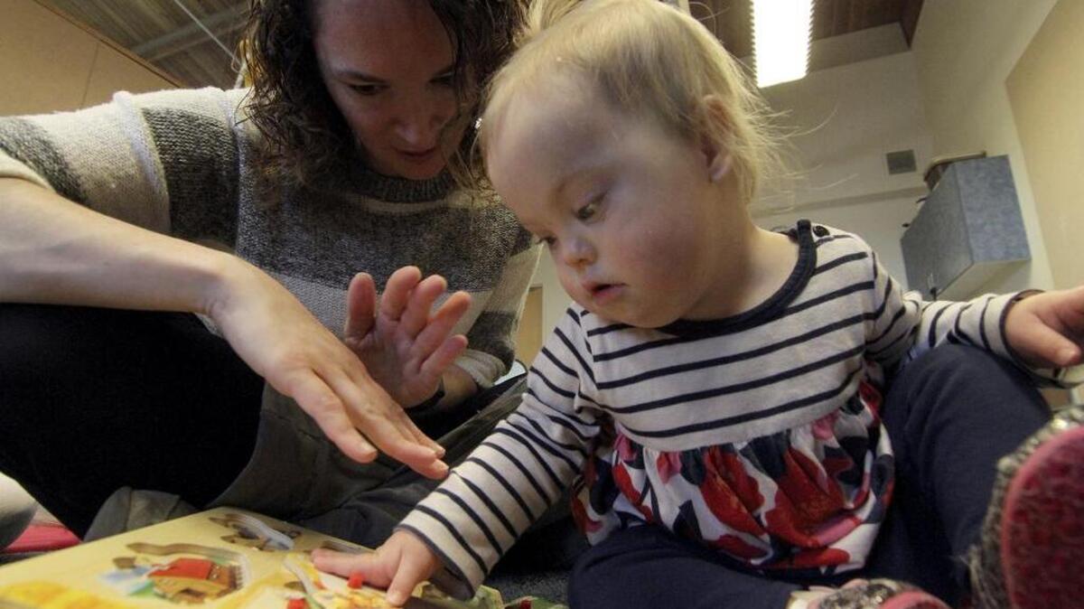 Good Samaritan Hospital child speech therapist Jessica Clark uses sign language with patient Claire Howell last week. Using a puzzle gives the 1-year-old a chance to associate sign language to ask to identify and communicate about the pictures and placement of the pieces.