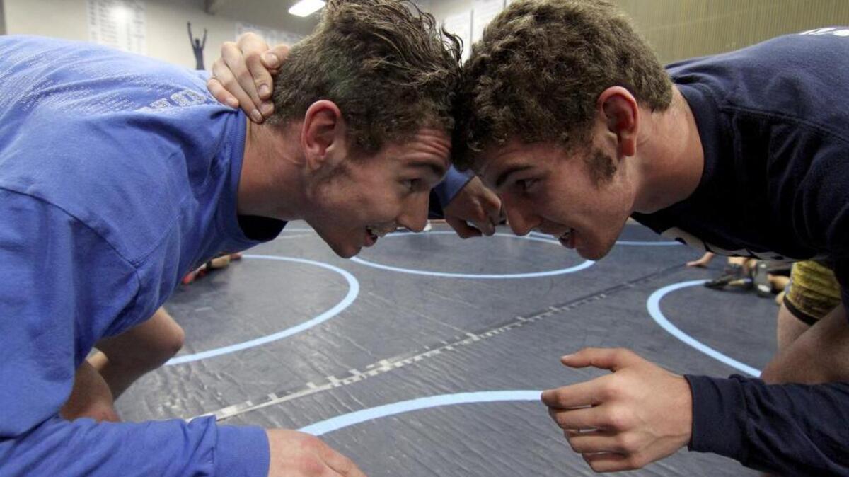 Twin brothers and Rogers High School wrestling team members Troy, left, and Ty Wilson square off last week during practice at the high school.