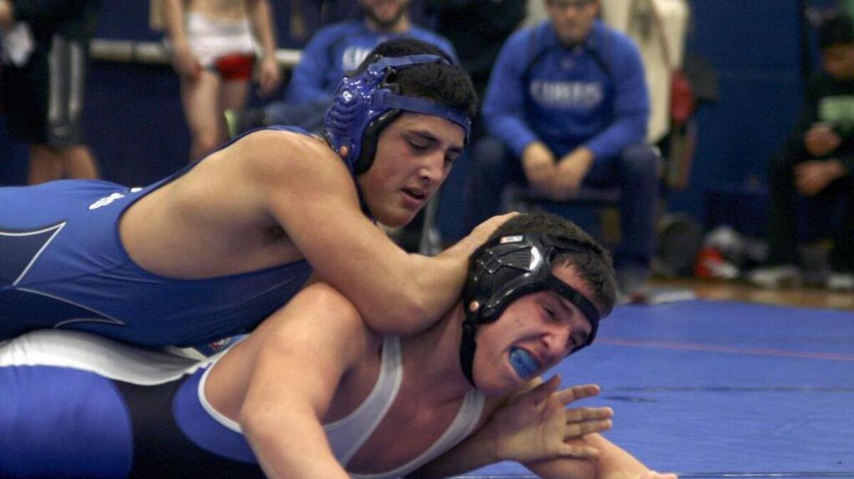 After picking up a 2-0 lead in the first round, Cascade Christian High’s Teave Metzger-Magalei, top, held on for two rounds to win the 195-pound championship over Curtis’ Luke Purcella at Saturday’s Rumble by the Riverside invitational at Auburn Riverside High.