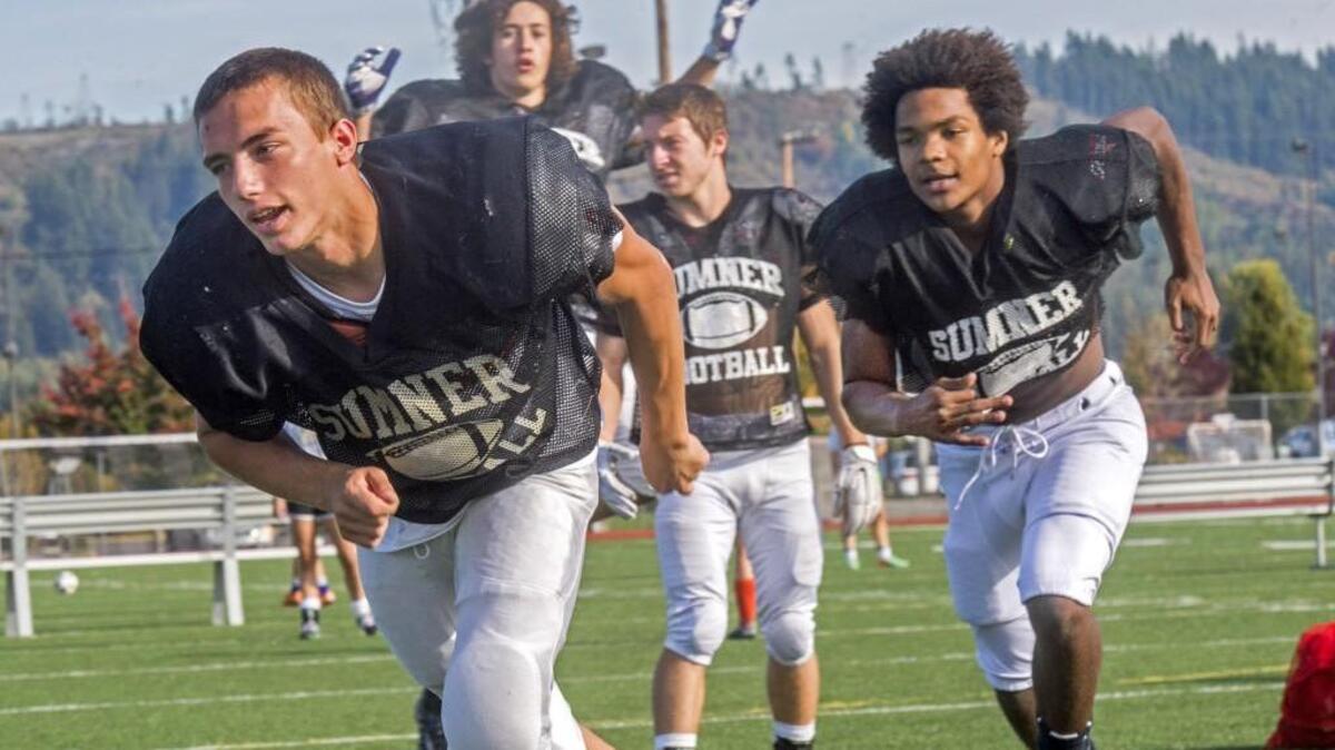 Sumner High running back Connor Wedington, right, runs through a play with teammate Josh Riley during football practice at the high school last year. Wedington, who just finished his junior season, verbally committed to play football at the University of Washington.