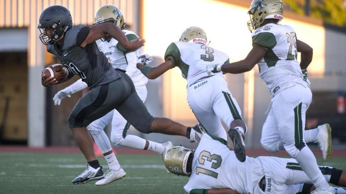 Bonney Lake High running back Marcus Hamilton breaks loose from Timberline defenders (from left) Tariq Romain, Issac Thompson (3), Jalen Bush (13) and Ty Edmund during Friday night’s football game at Sunset Chev Stadium.
