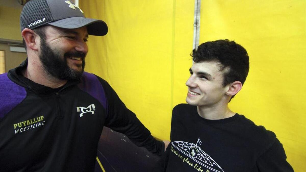 Josh Franich, a junior wrestler at Puyallup High School, is hearing impaired and uses a device to hear out of his right ear only. The wrestler visits with his father, Brian, a former coach for the team.