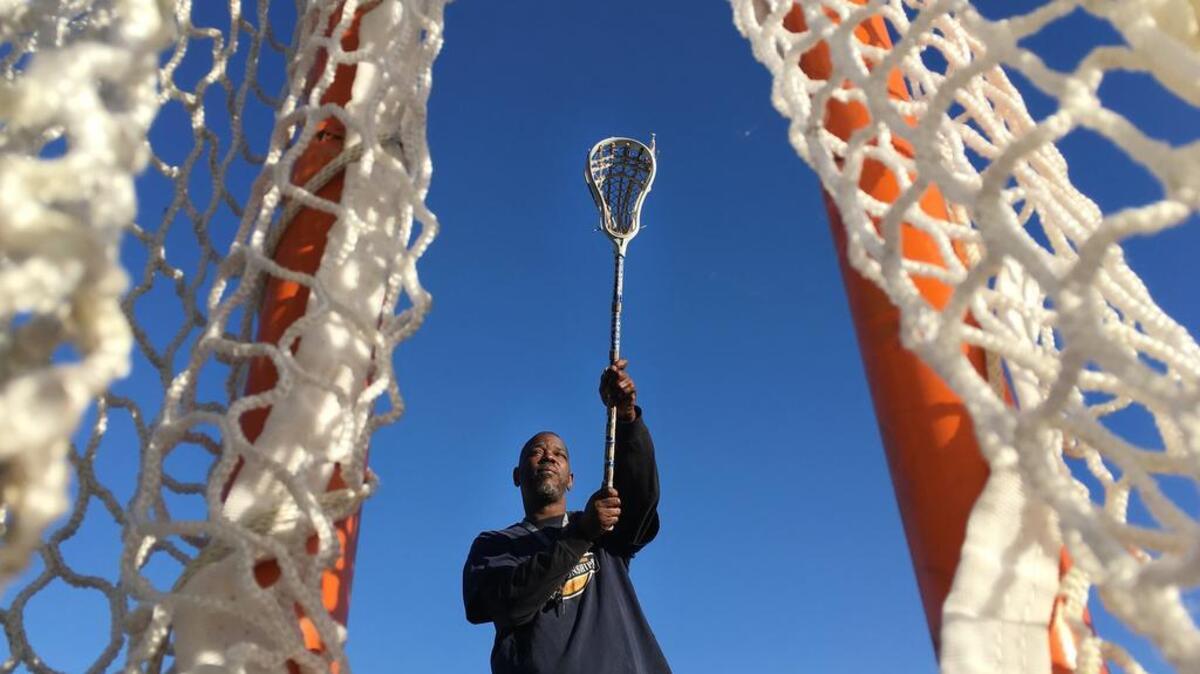 Larry Mackey demonstrates an overhand shot with the Elite Shot, a tool he created to help lacrosse players learn how to properly shoot overhand.