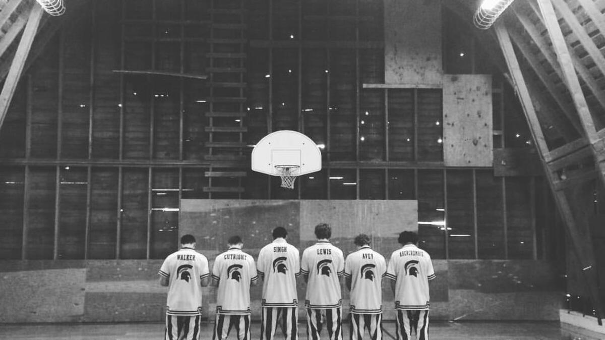 Huddled together on a regulation-size basketball court constructed inside a barn in Enumclaw, the Sumner High boys basketball team posed for a team picture.