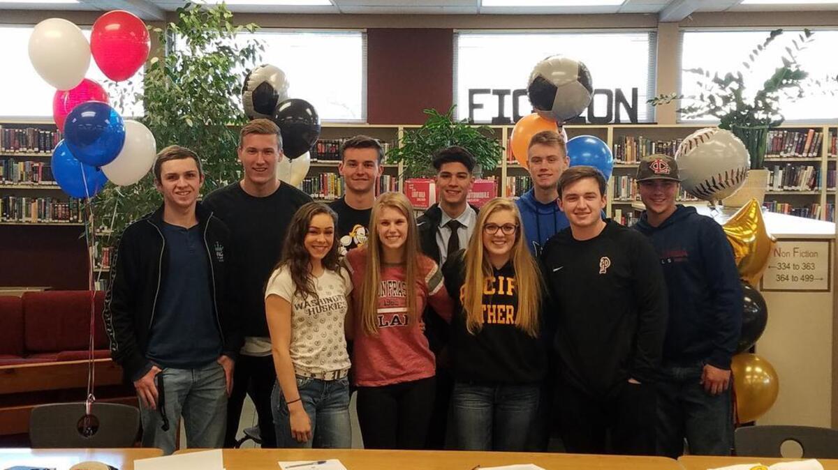 Puyallup High had 10 athletes commit to colleges over seven sports on National Signing Day inside the school library. Front (left): Geneva Thompson, Brooklyn Bartelson, Kennedy Robillard and Ryan Teague. Back: Rowan Poppen-Eagan, Gavin Dunayski, Sam Ebner, Brayan Torres, Tallon Yerbury and Zack Larson.
