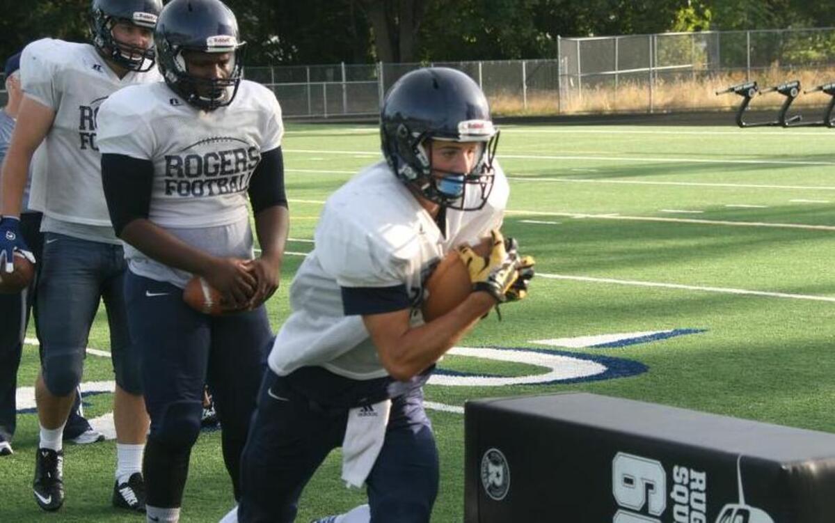 
Ethan Norris carries the ball during a tackling drill Monday at the high school. Rogers’ defensive unit is trying to use August camps to help establish the team’s identity. 
