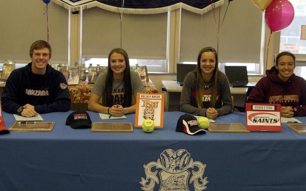 Rogers High athletes, from left, Troy Johnson (Gonzaga), Kelsey Breer (Idaho State), Jessica O’Toole (Saint Martin’s University) and Sasha Killings (Bethune-Cookman University) sign their letters of intent during a ceremony last week at the high school.