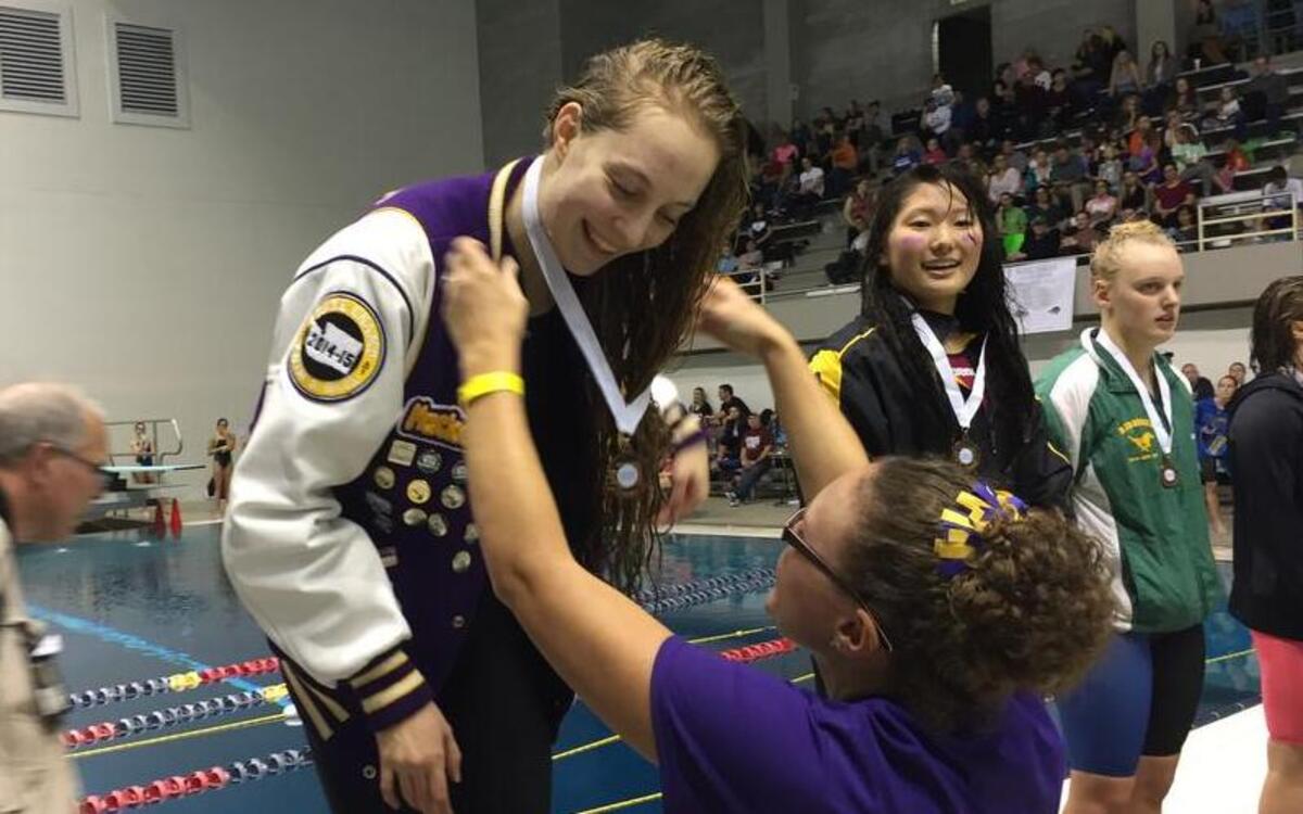 Puyallup High senior Mackenzie Mergel is awarded a medal for her fifth-place finish in the 200-yard freestyle with a time of 1 minute, 55.47 seconds Saturday at the Class 4A state swim meet at the King County Aquatic Center.
