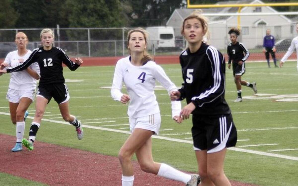 Freshman Katie Matthews (5) positions herself for an Emerald Ridge High throw-in as Puyallup High midfielder Katelynn Wood (4) tries to fight for the ball during a match Saturday at Sparks Stadium.