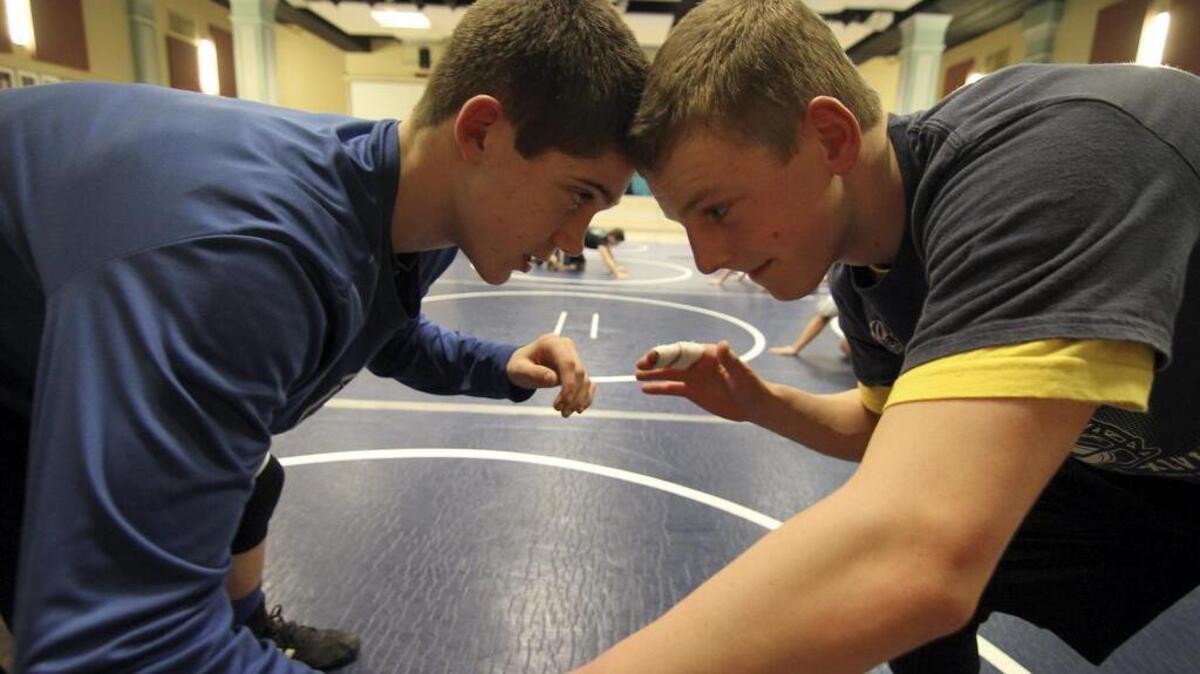 Cascade Christian High junior Sean Hussey, right, works on some wrestling moves with teammate Michael Gurr last week at practice. Hussey is slowly working his way back from suffering a torn meniscus last season.