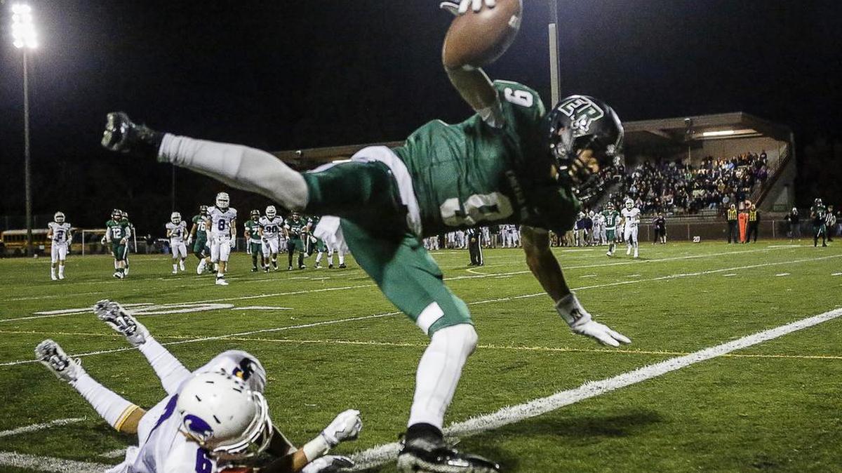 Emerald Ridge's Andrew Boston (9) leaps into the end zone for a touchdown in the second quarter of a game against Sumner High School at Sparks Stadium October, 28, 2016.