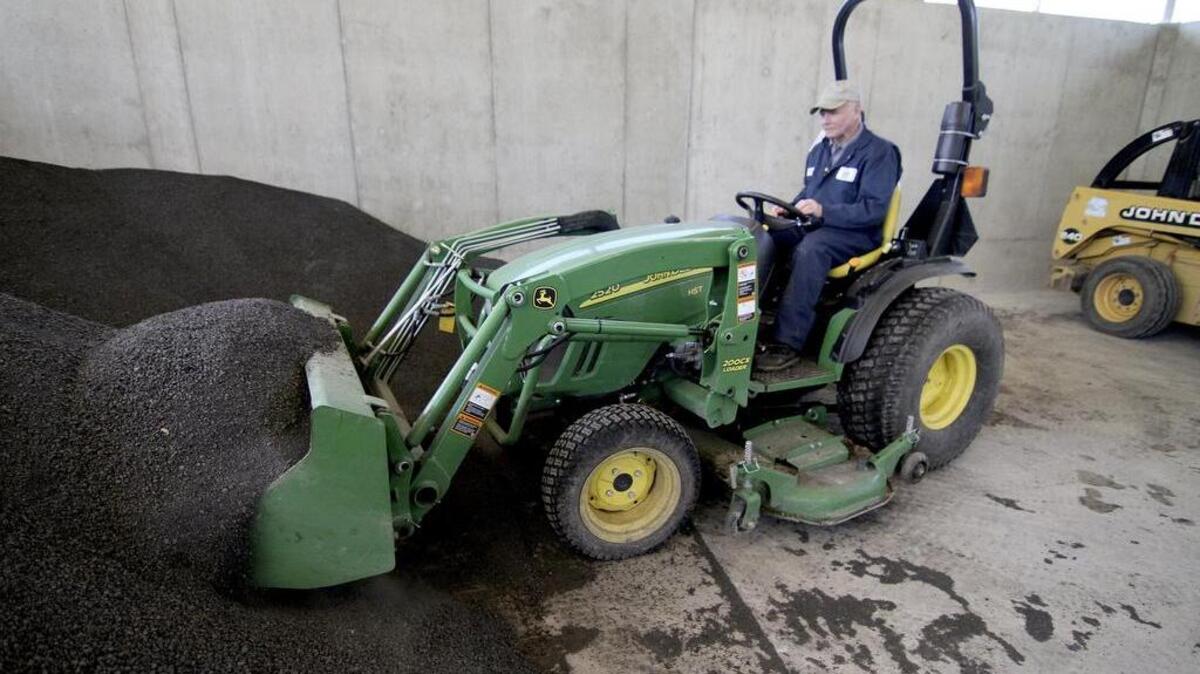 Sumner Wastewater Treatment Plant maintenance technician Fred Miller uses a tractor to move the Sumner Grow product to the outside distribution stand at the Sumner facility.