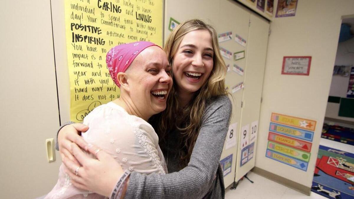 Sumner High School Tiny Sparts Daycare teacher Lisa Joyce Nelson hugs student Katie Rink, student coordinator of Benefit Night, an event to raise money to help defer costs of breast cancer treatment for Nelson.