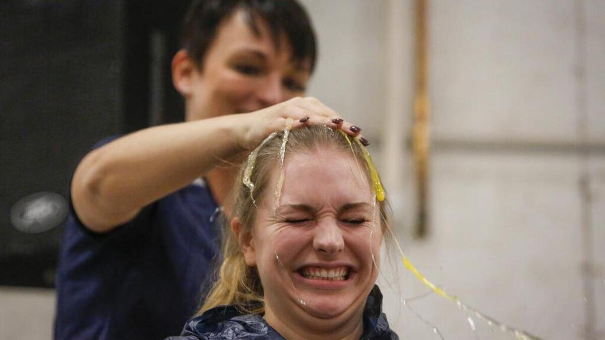 HR manager Martha Koch smashes an egg on Shelby Beier’s head during a company-wide game of Egg Roulette at a Blue Friday event at the Bellmont Cabinet Company in Sumner.