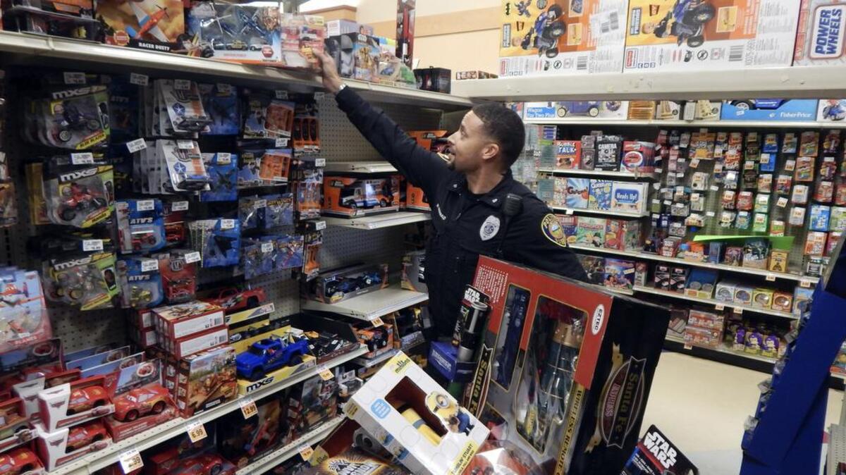 Sumner police officer Marcus McDonald shops for gifts for the department’s toy drive last week at Fred Meyer in Sumner.