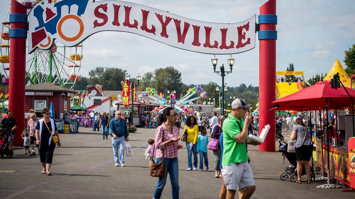 People walk through Sillyville at the Washington State Fair in Puyallup last fall. The fair is holding a job fair July 31.
