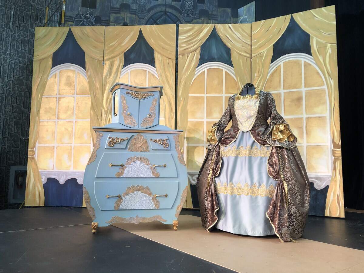Two costumes for the same character in "Beauty and the Beast" sit atop the stage at All Saints Parish Hall in Puyallup.