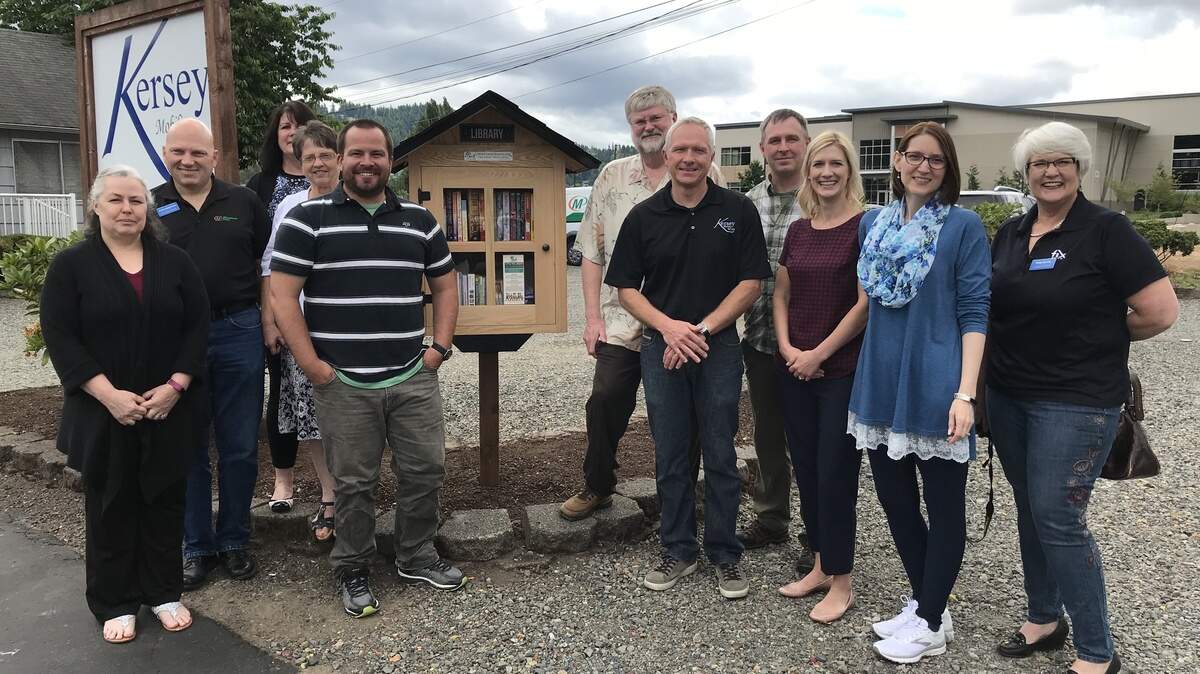 Members of the Puyallup/Sumner Chamber of Commerce Leadership Institute stand in front of the Little Free Library in Sumner they built for the community.