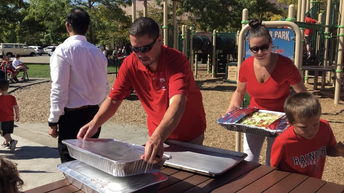 Caleb Lara, left, and Carissa Lara place food donated by local restaurant owner Ramesh Kumar out on tables at Pioneer Park in Puyallup during a teacher rally Sept. 7.