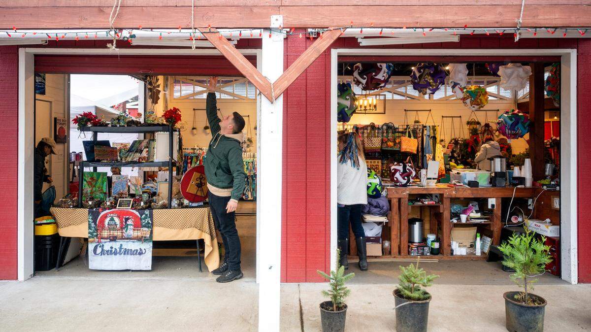 Dennis Kupchenko, 24, owner of the Red Barn Market and Nursery near Puyallup, opens up one of the garage doors to the barn as he prepares for Friday’s sale to start. On Tuesday, Dec. 7, Kupchenko had his store vandalized and robbed. The community came to his aid with a GoFundMe campaign and he was back, open for business later in the week.