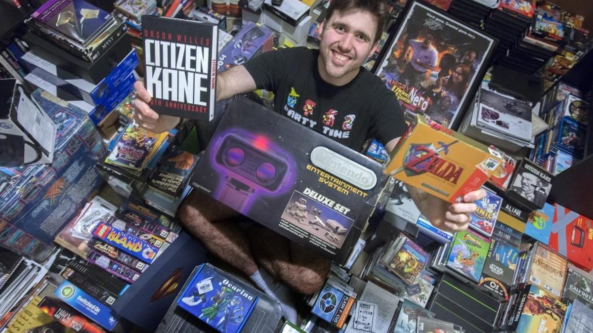 Christopher Cline holds his favorite classic movie and video game system Thursday. Cline has more than 1,500 classic movies and video games. This is a new collection after his old collection was stolen from a storage unit in Tacoma.