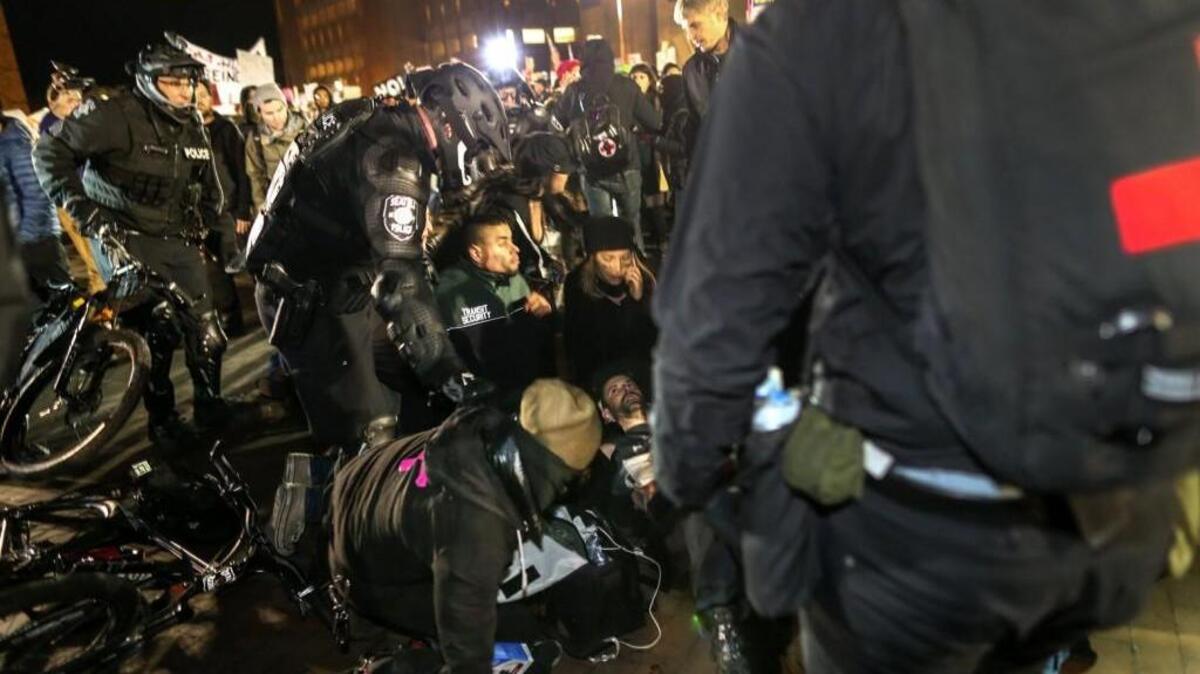 Police move in to help a man who was shot in the stomach during a protest in front of Kane Hall on the University of Washington campus on Jan. 20, 2017, in Seattle. Clashes between protesters and those looking to attend a speech by former Breitbart editor Milo Yiannopoulos at Kane Hall on the day that Donald Trump was sworn in as president resulted in numerous skirmishes before the shooting.