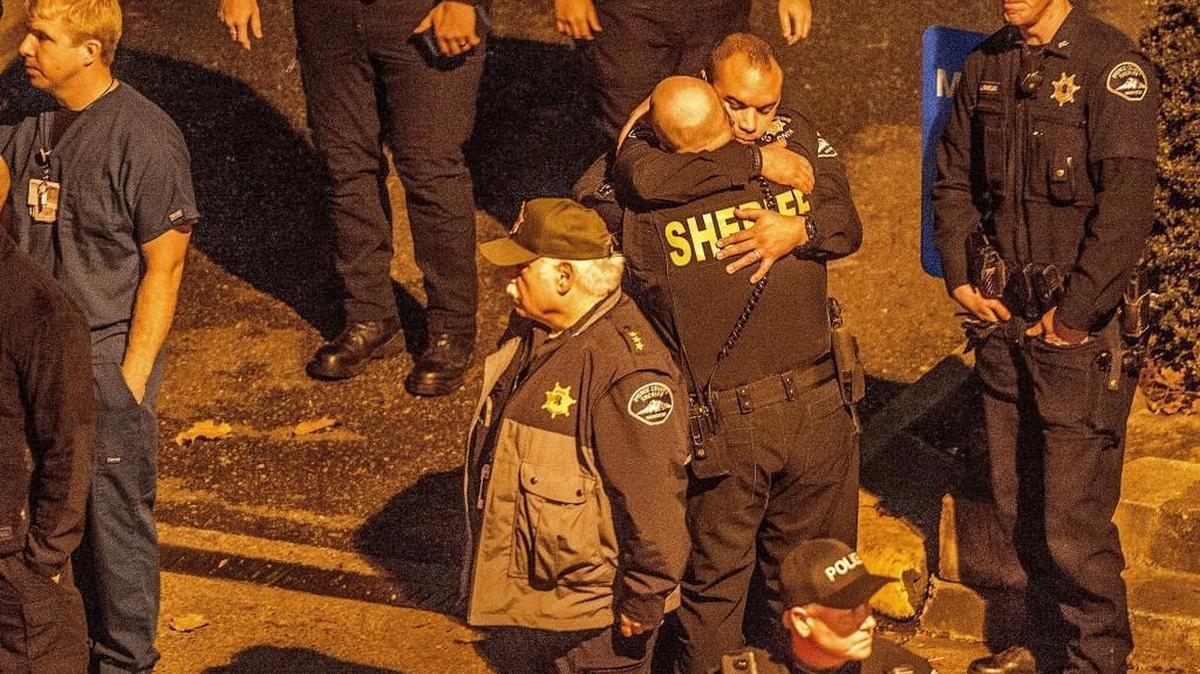 Law enforcement officials comfort each other outside Tacoma General Hospital as they wait for the body of slain officer Reginald “Jake” Gutierrez to be released Wednesday night.