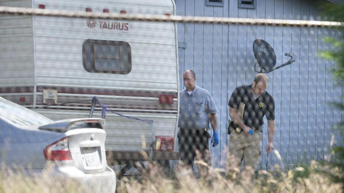 Thurston County Sheriff’s deputies investigate at the scene of a quadruple shooting — with three people left dead — on Dutterow Road Southeast east of Lacey on Wednesday.