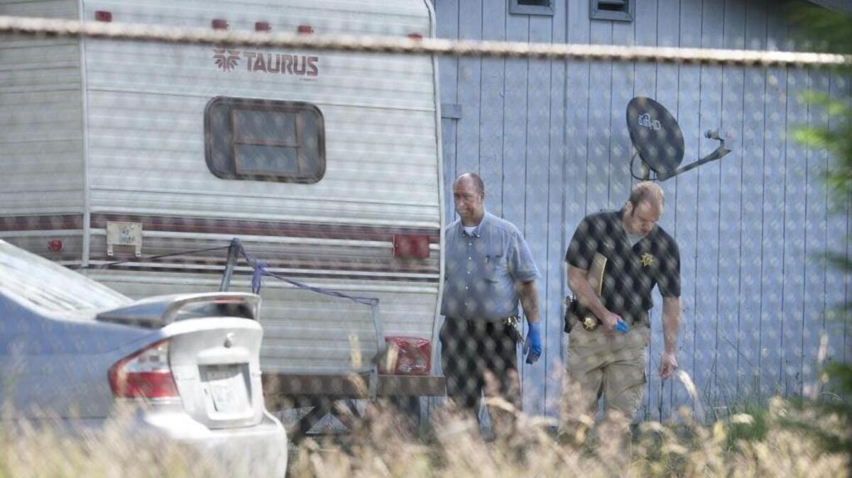 Thurston County Sheriff’s deputies investigate at the scene of a quadruple shooting — with three people left dead — on Dutterow Road Southeast east of Lacey on Wednesday.
