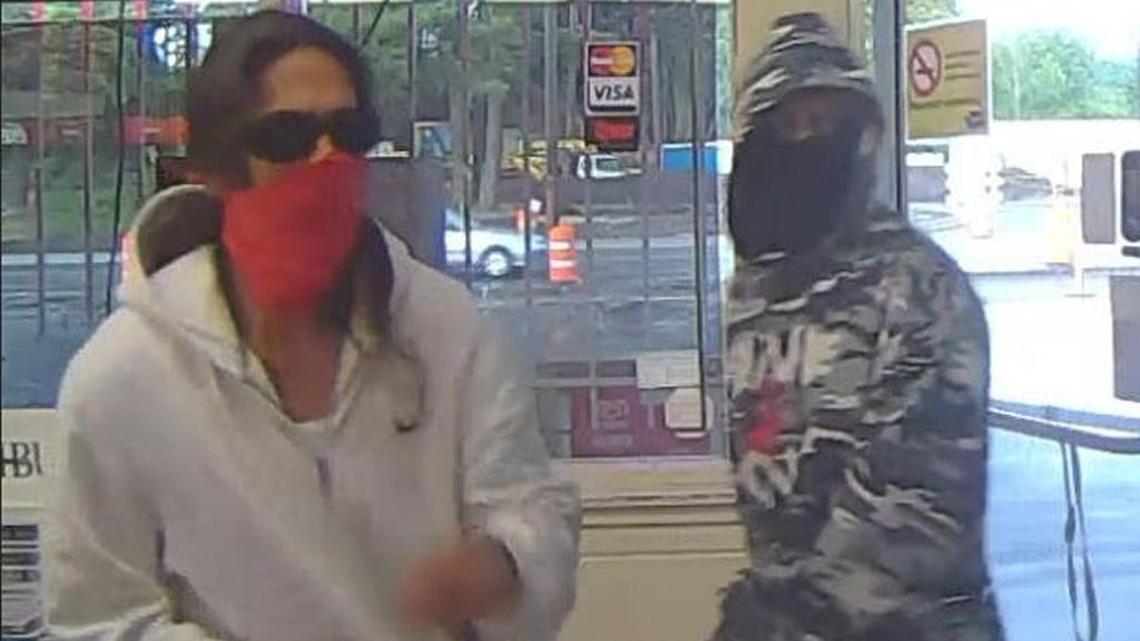 Two suspects are seen robbing a Lakewood grocery store Wednesday in this image from a surveillance camera.