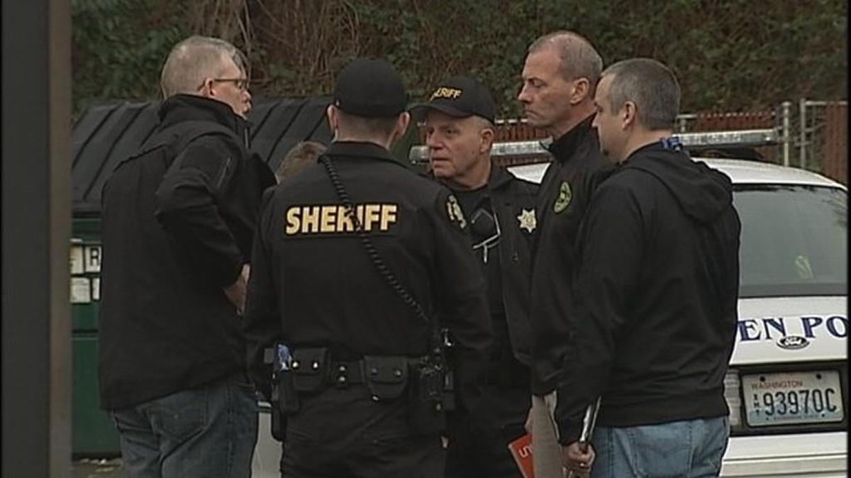 Investigators work a crime scene at a convenience store in the Boulevard Park area of South King County early Sunday. A masked man wielding a hatchet walked into the store swinging before he was fatally shot by a customer.