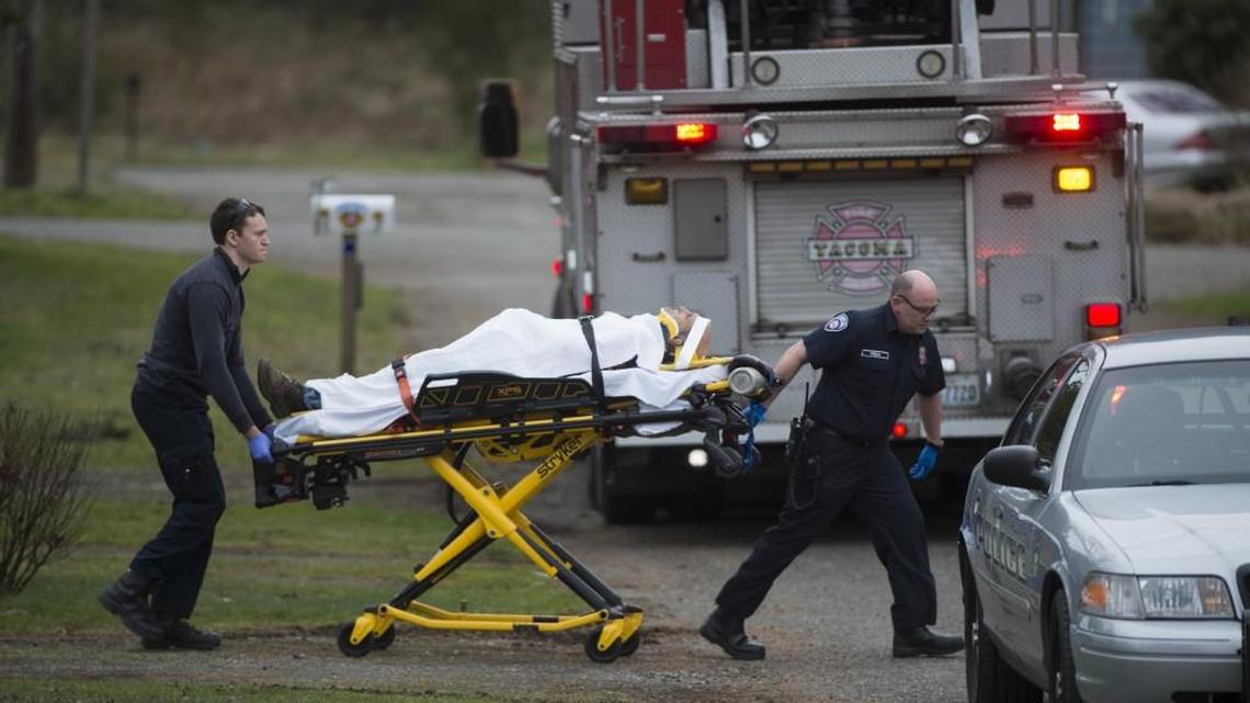 A man is moved into an ambulance after a shooting near the 2400 block of South 52nd Street in Tacoma, Wash., on Wednesday, Feb. 28, 2018.