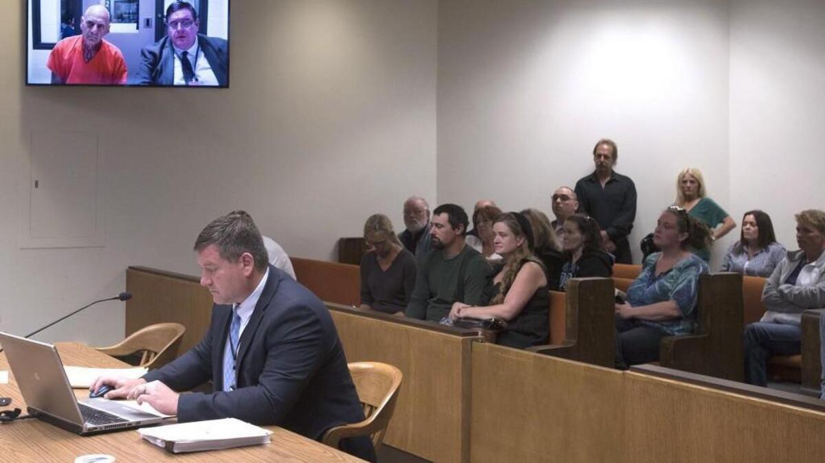 James E. Stidd, left, appears Friday with his attorney John Hansen via video in Thurston County Superior Court in Olympia. In the foreground is Deputy Prosecutor Scott Jackson.