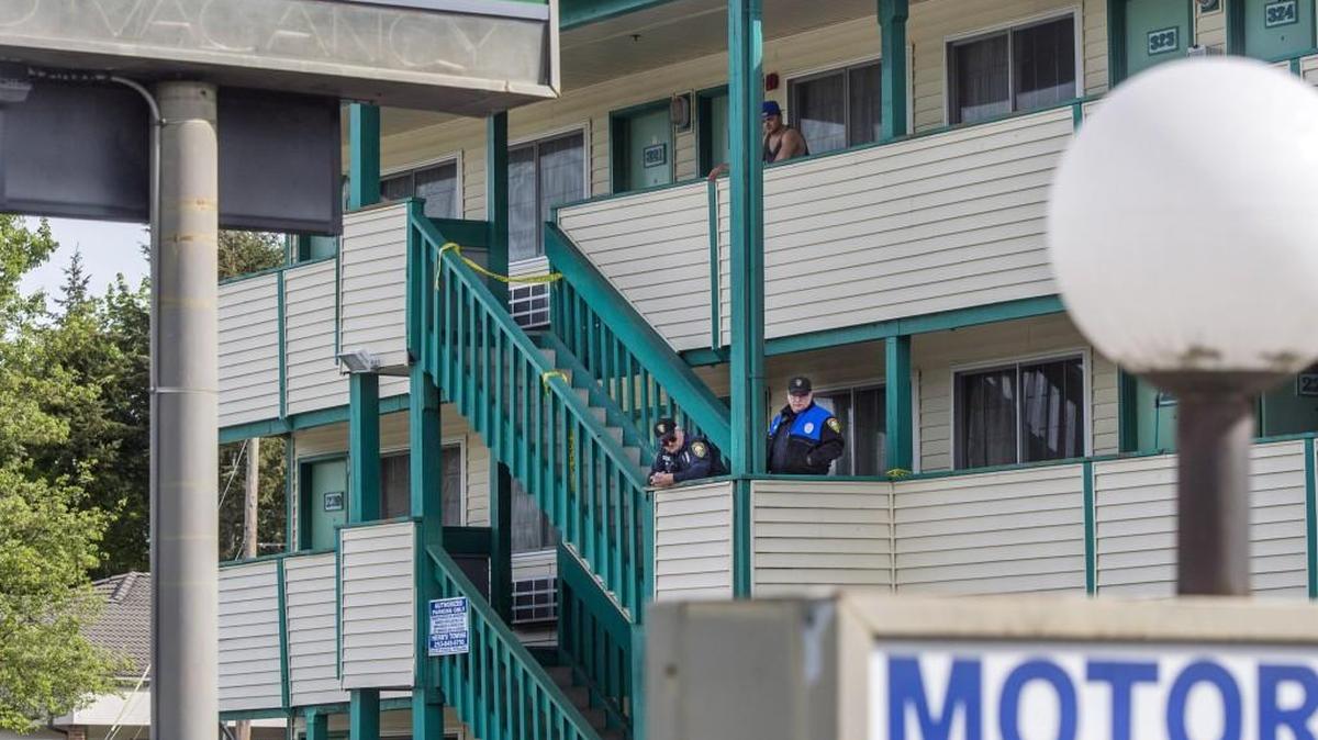 Puyallup police investigate the scene of a shooting at a motel on South Meridian on Saturday. One man was killed early Saturday and a suspect has been taken into custody.