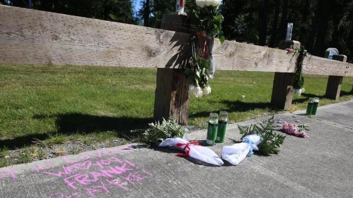 A note written in chalk, burning candles and flowers mark the Federal Way site where a man was fatally shot.