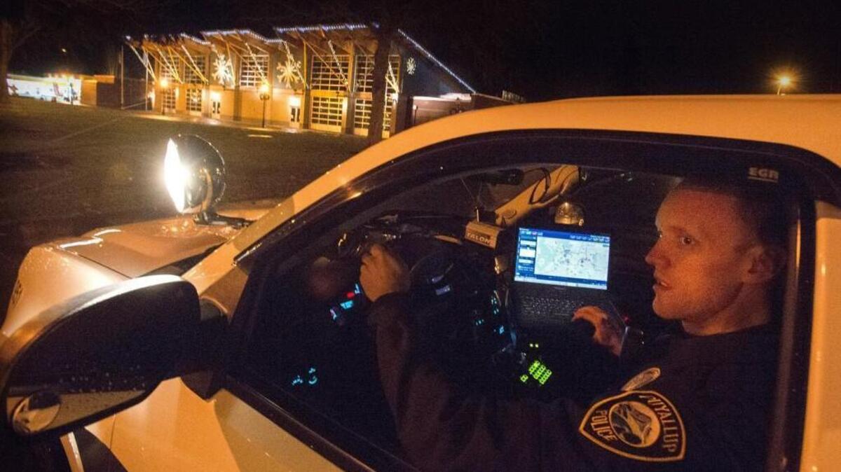 Puyallup Det. Micah Wilson, seen in his cruiser Dec. 6, is one of two officers who will receive the Washington State Law Enforcement Medal of Honor for their actions during an August shooting.
